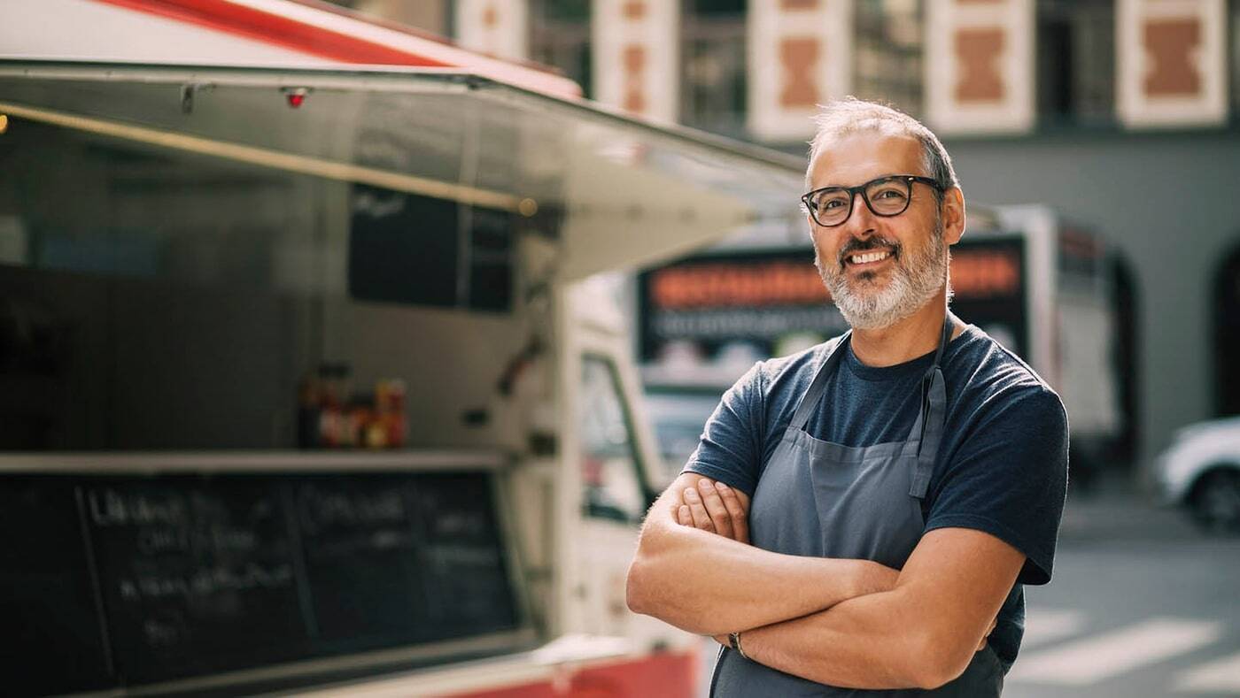 Uomo in piedi davanti a un furgone di street food