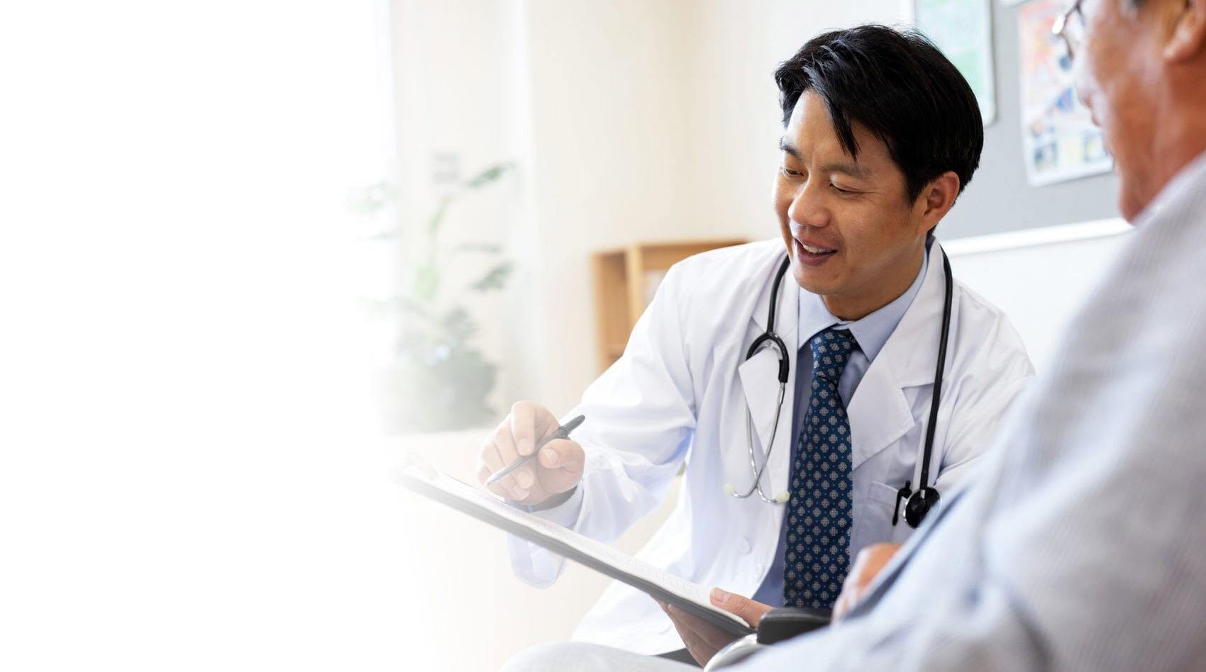 Medico che scrive sul referto di un paziente